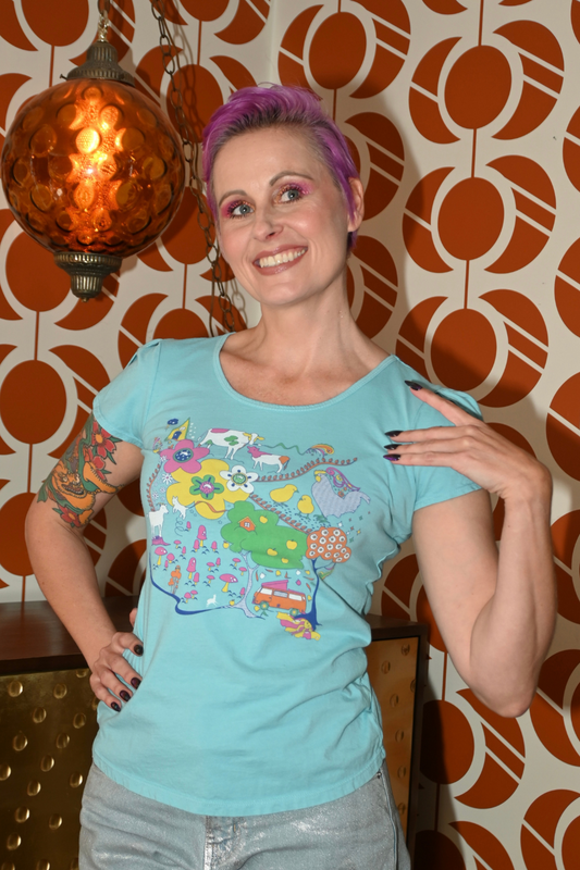 Cute model in light blue graphic tee with animals in front of cool wallpaper