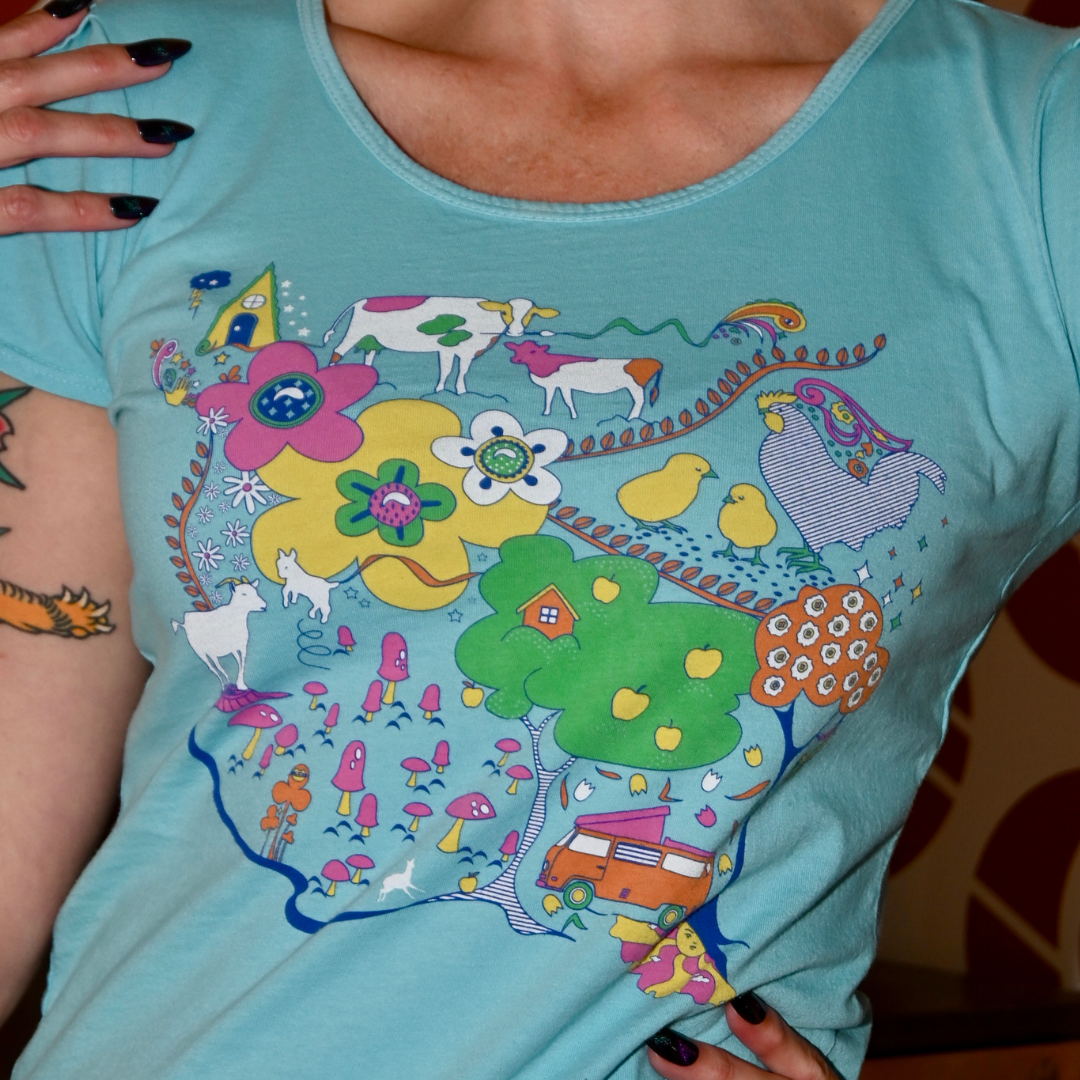 Cute model in light blue graphic tee with animals in front of cool wallpaper