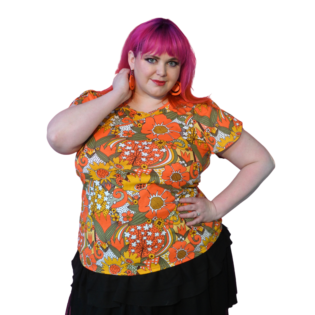 Attractive pink-haired model wearing bright colored tee with large floral print