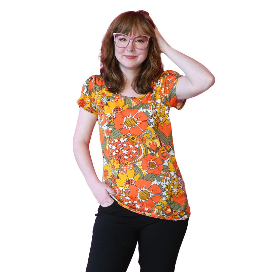Girl in glasses wearing bright colored floral tulip-sleeved tee