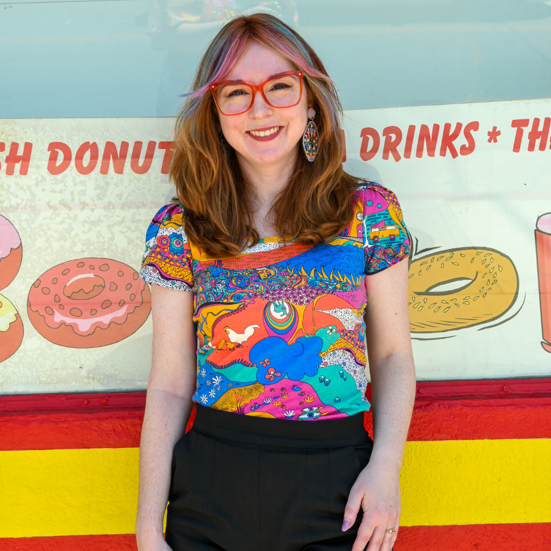 Model wearing bright glasses and fun, retro tee featuring plants and animals