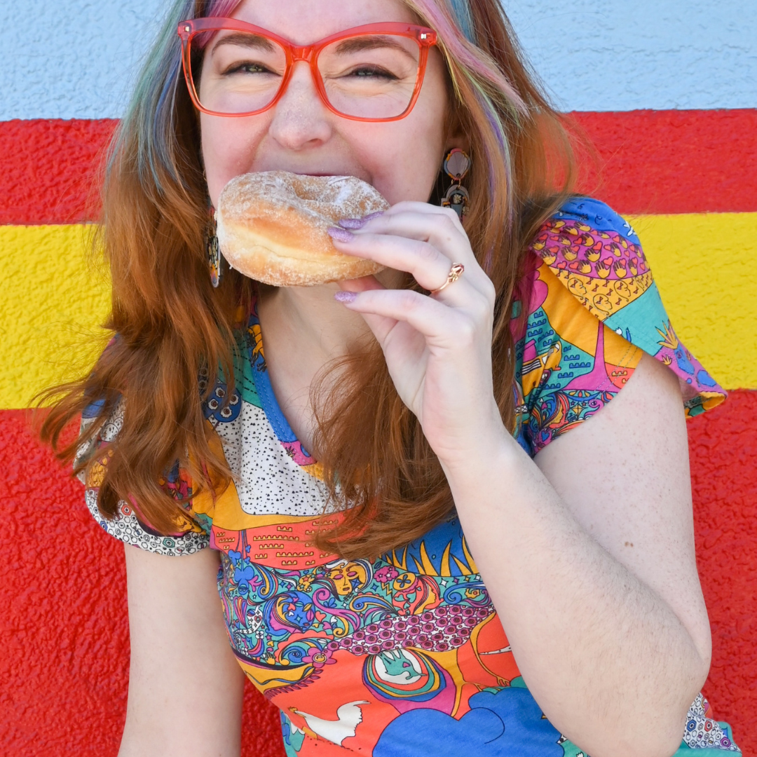 Closeup of model eating brightly colored tee and eating a doughnut