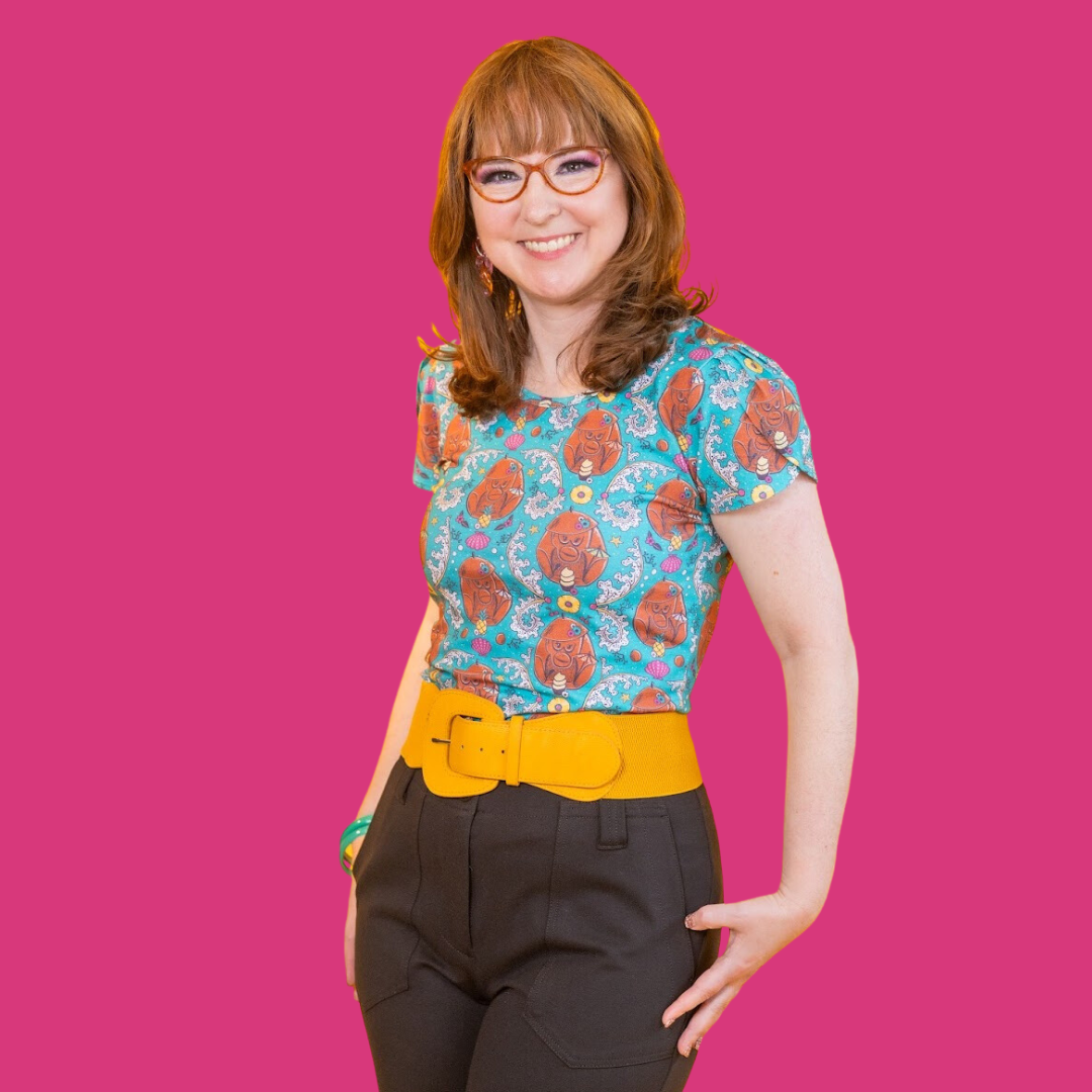 Brown-haired model in teal coconut monkey and pineapple print shirt