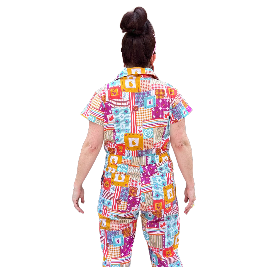Back view of model wearing sunglasses and patchwork print zip-front collared jumpsuit