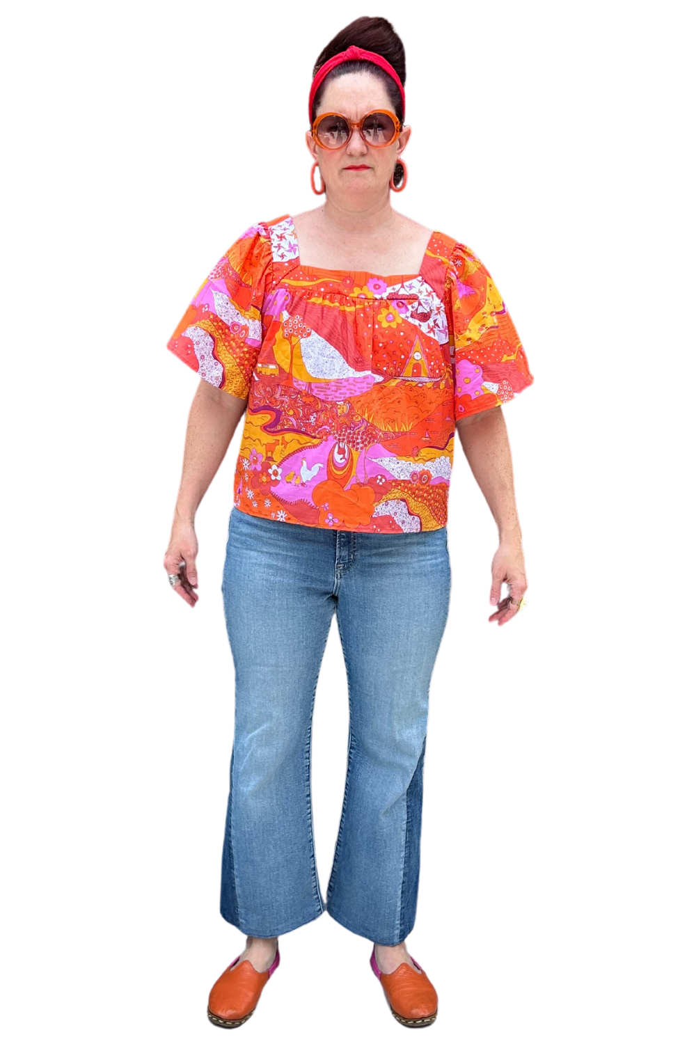Model in brightly colored woven square-neck top with landscape print in pink, orange and yellow