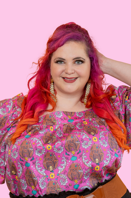 Bright-haired model in magenta monkey print cotton top