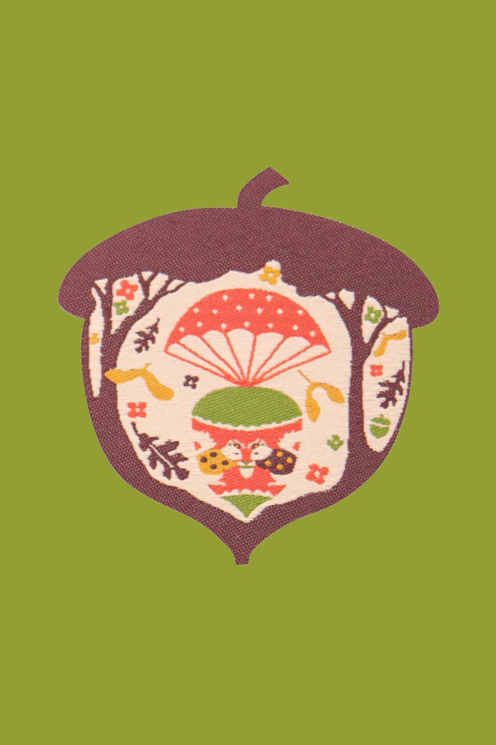 Brown, green and orange acorn-shaped iron on patch with parachuting squirrels and leaves