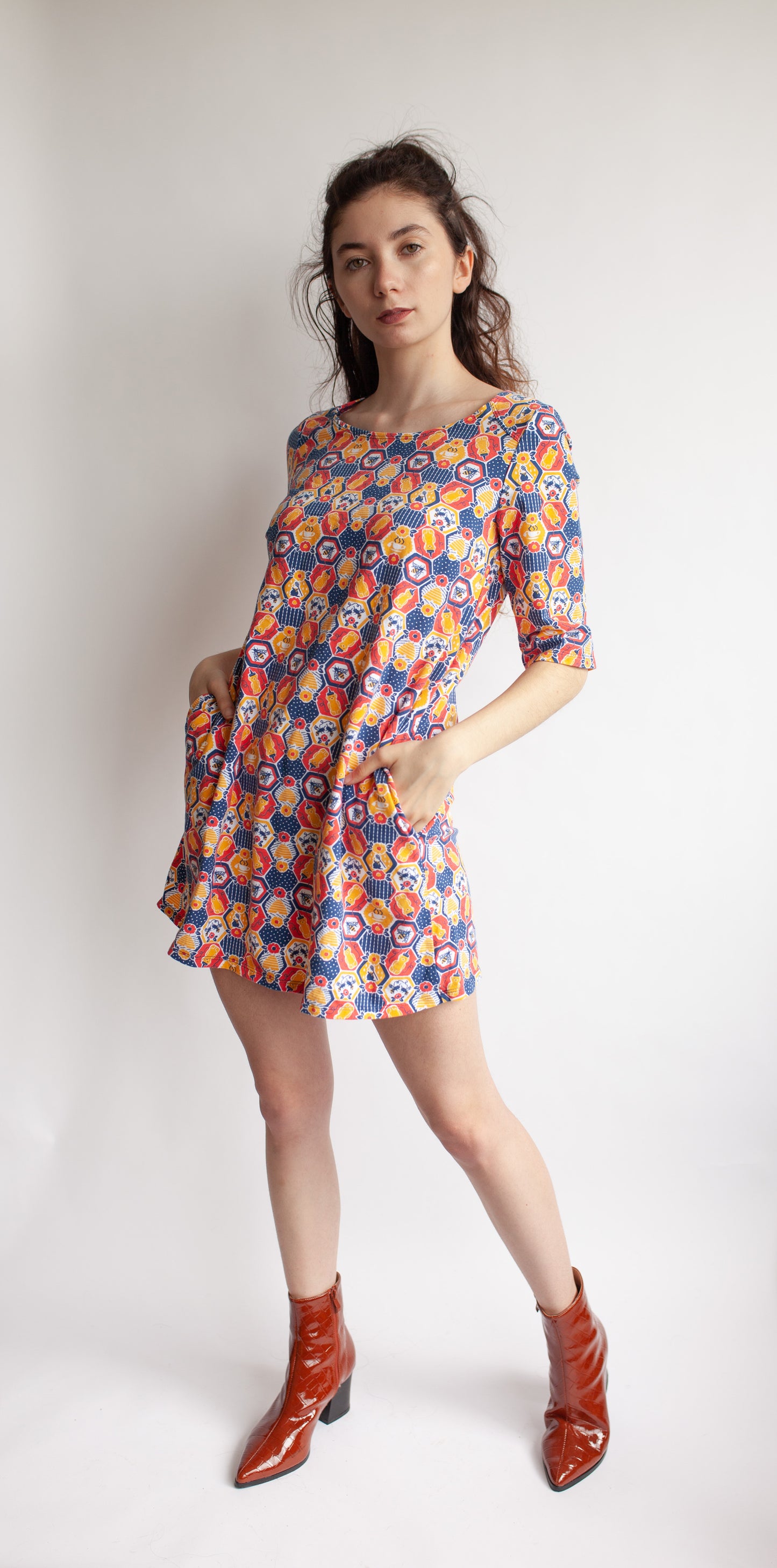 Red, yellow and navy blue hexagon print pocket tunic on model with red ankle boots