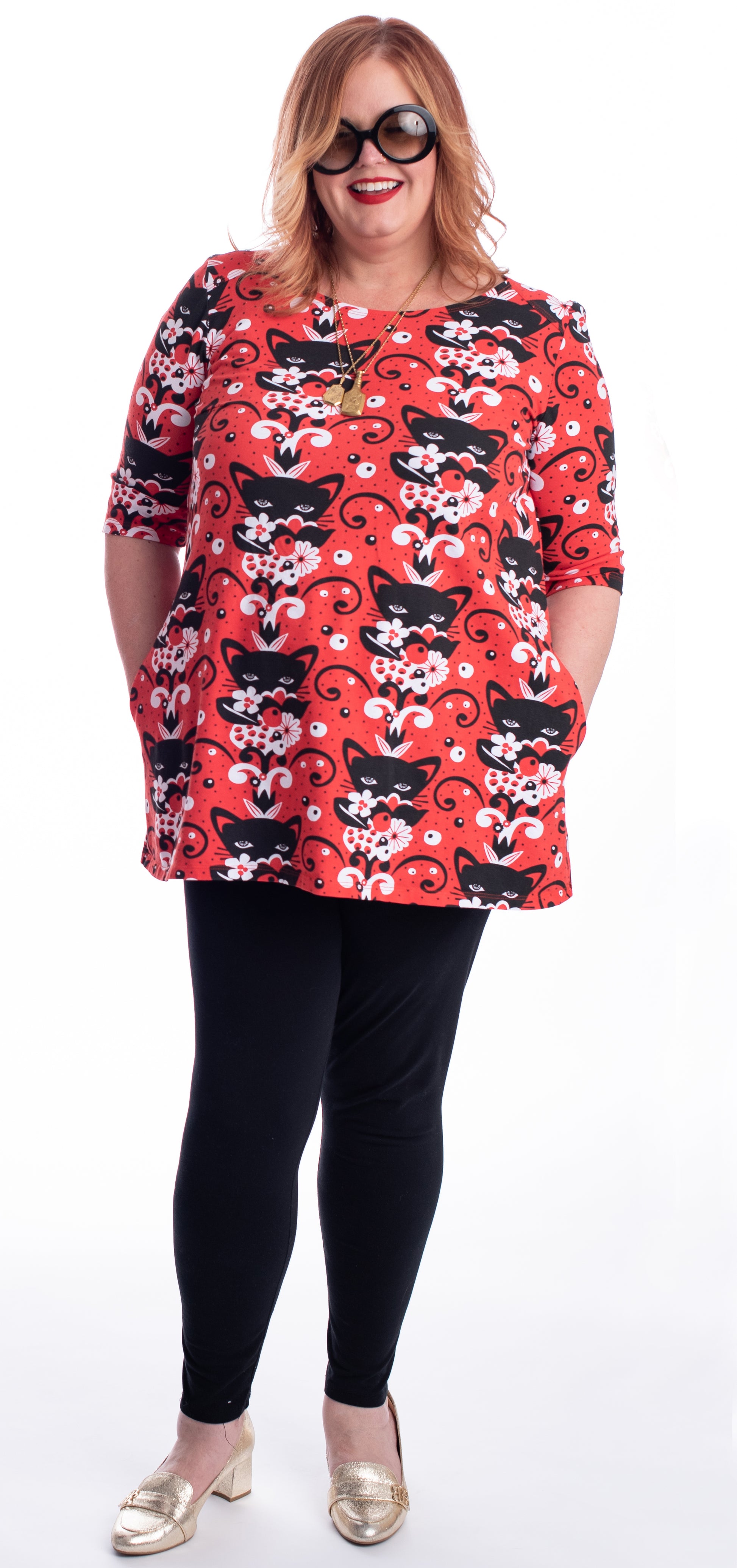 Red black and white a-line pocket tunic with  print of cats and flowers on model, full body view