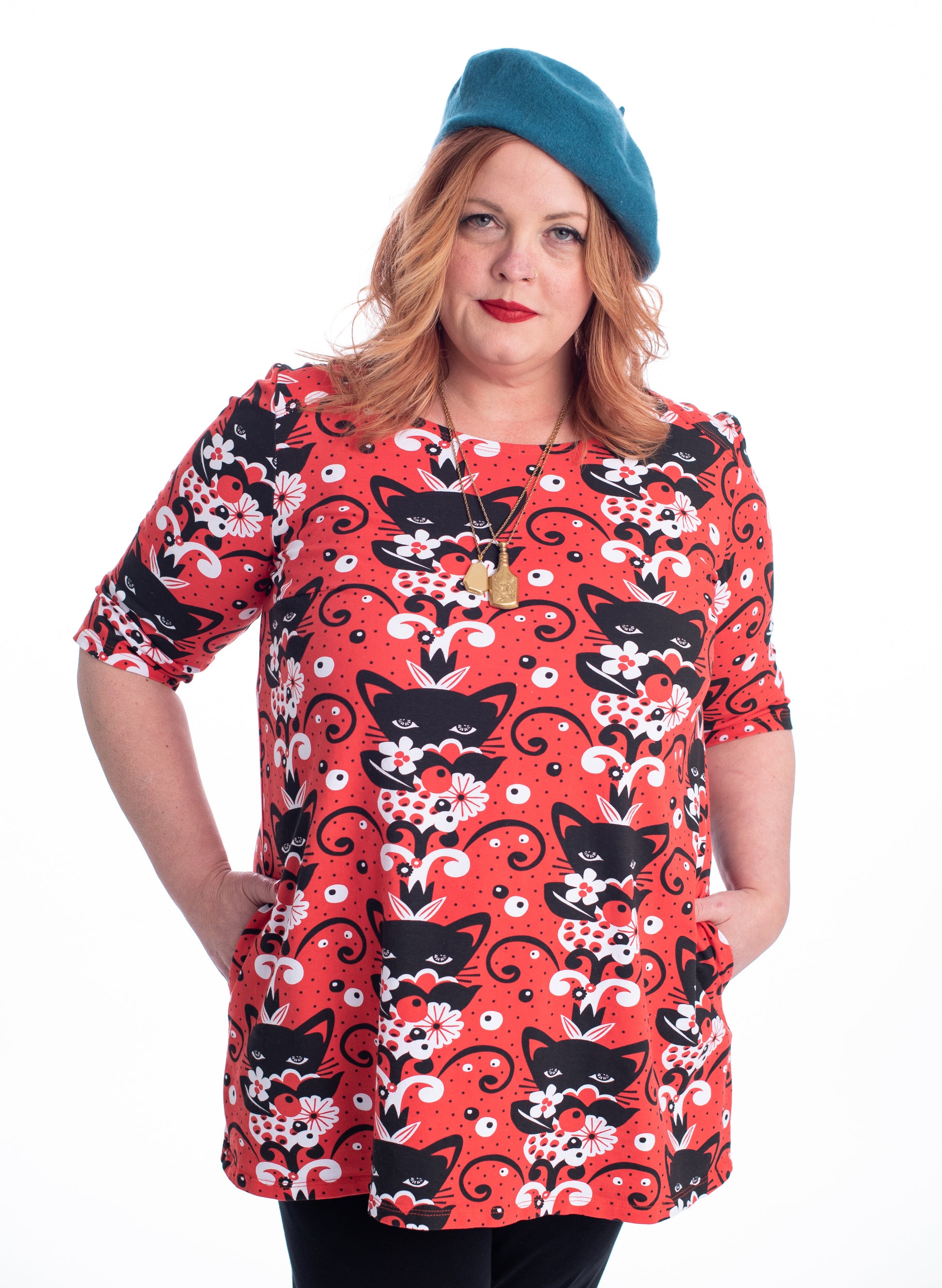 Red black and white a-line pocket tunic with  print of cats and flowers on model with beret