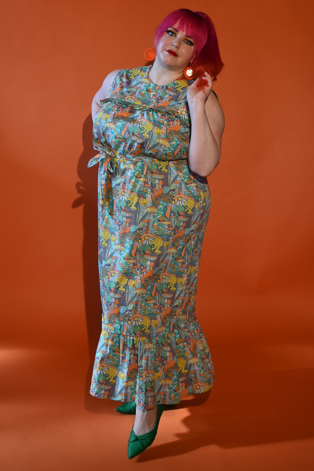 Gorgeous pink-haired model in mushroom print maxi dress in teal, yellow and orange