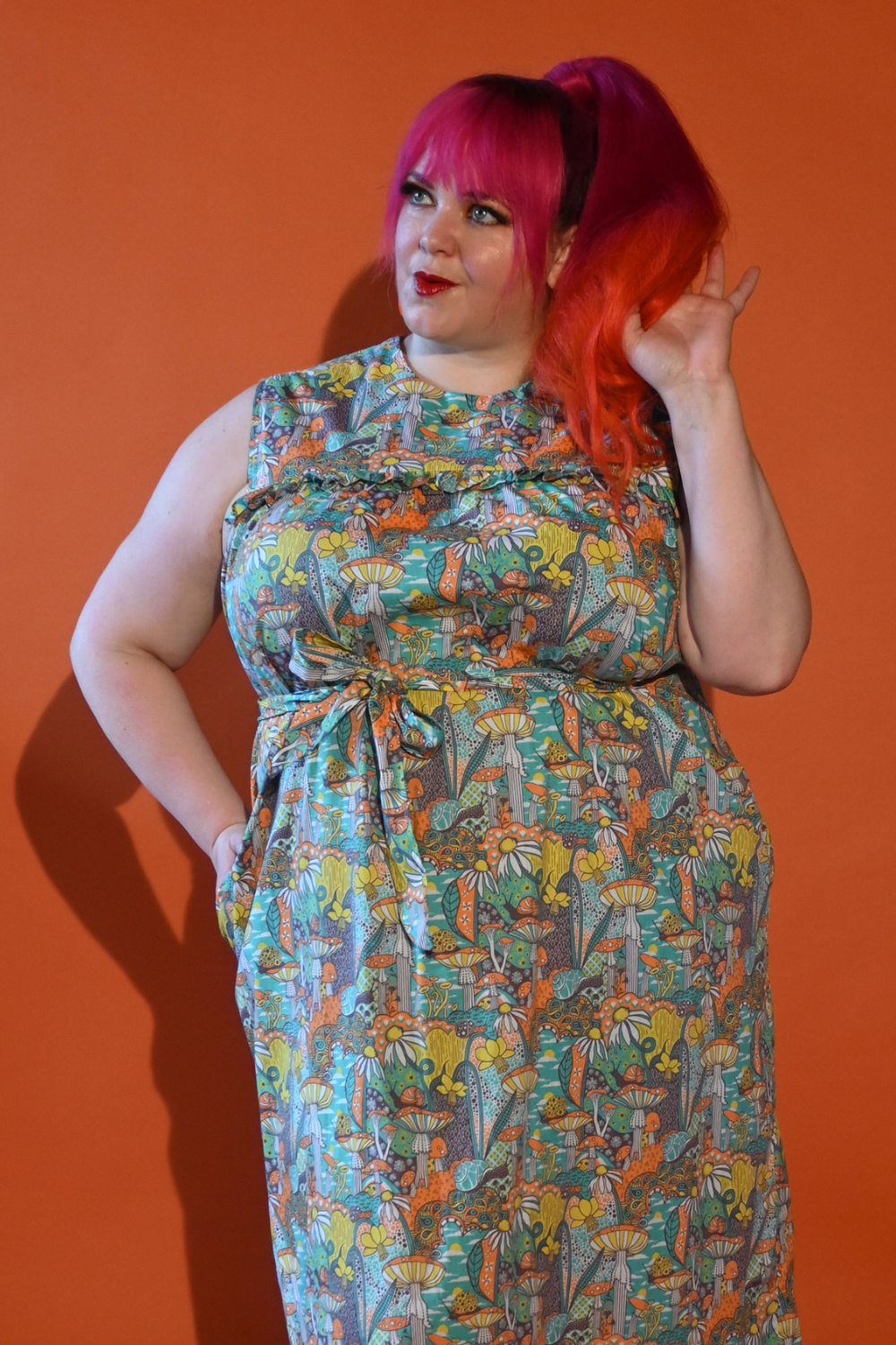 Gorgeous pink-haired model in mushroom print maxi dress in teal, yellow and orange
