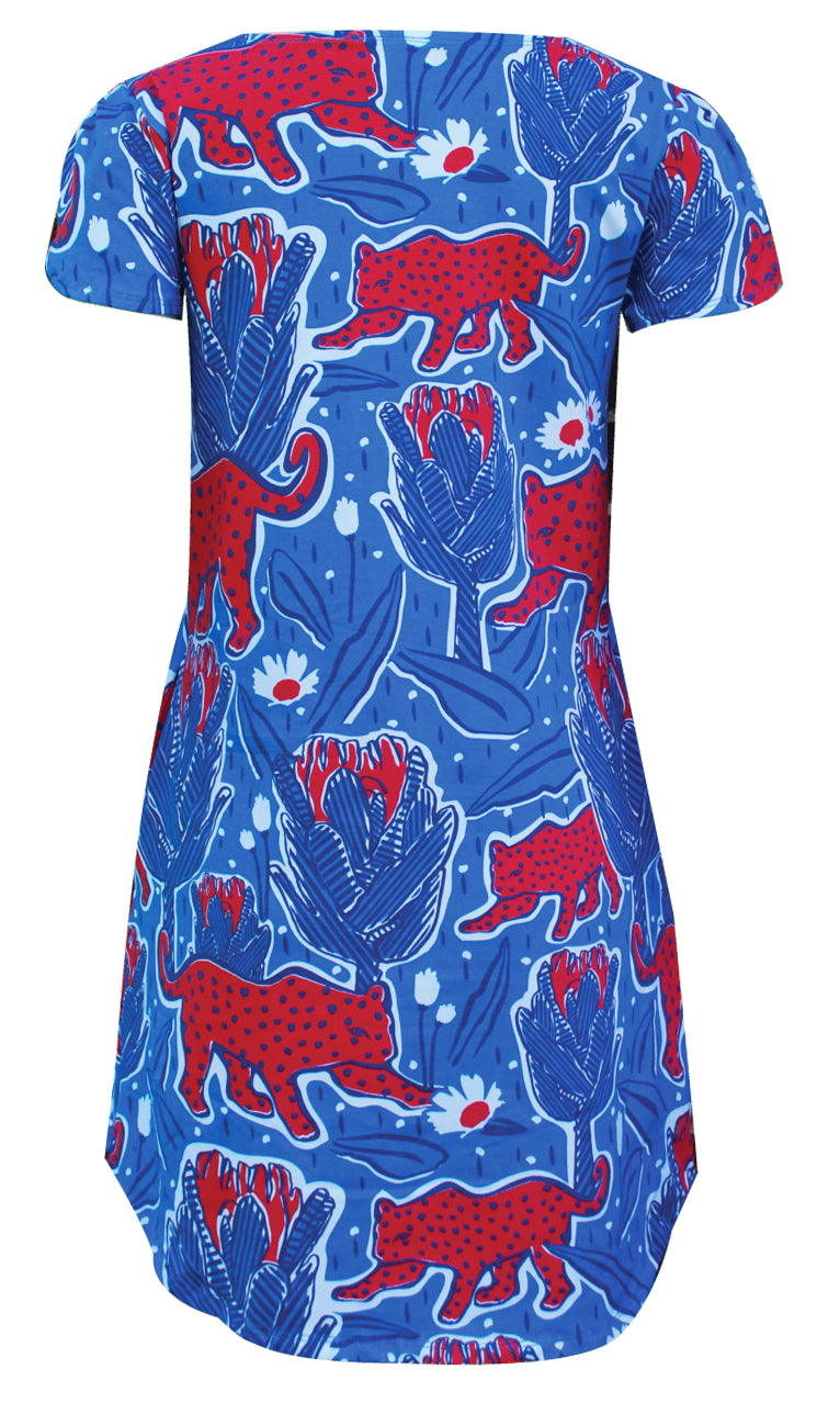 Back view of bright blue and red tulip-sleeved tunic with print of jaguars and protea flowers
