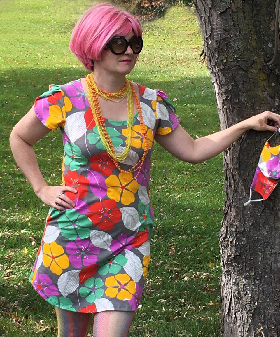 Pink haired model wearing a colorful dress with tropical flowers 