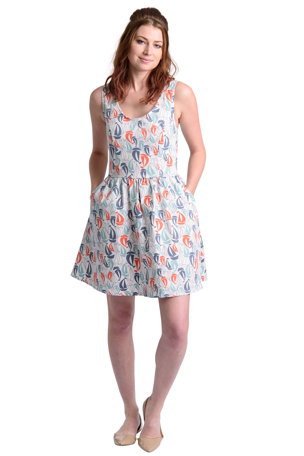 Model in white fit and flare dress with red and blue sailboat print and pockets