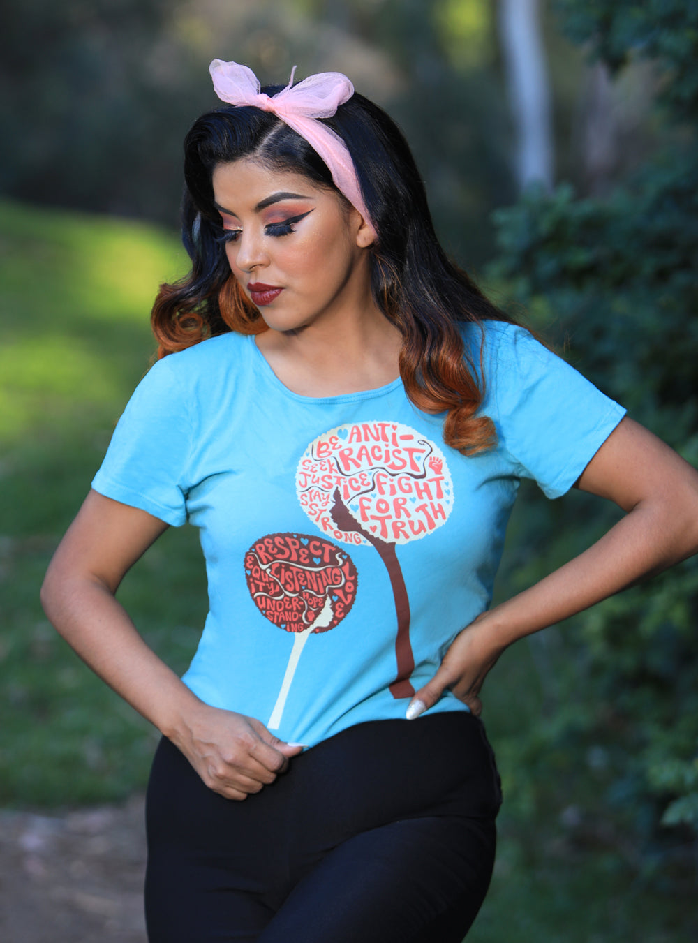 Light blue tee with design of afro girls or flowers with anti racist messages