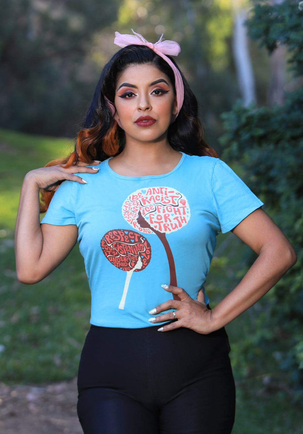 Light blue tee with design of afro girls or flowers with anti racist messages on model