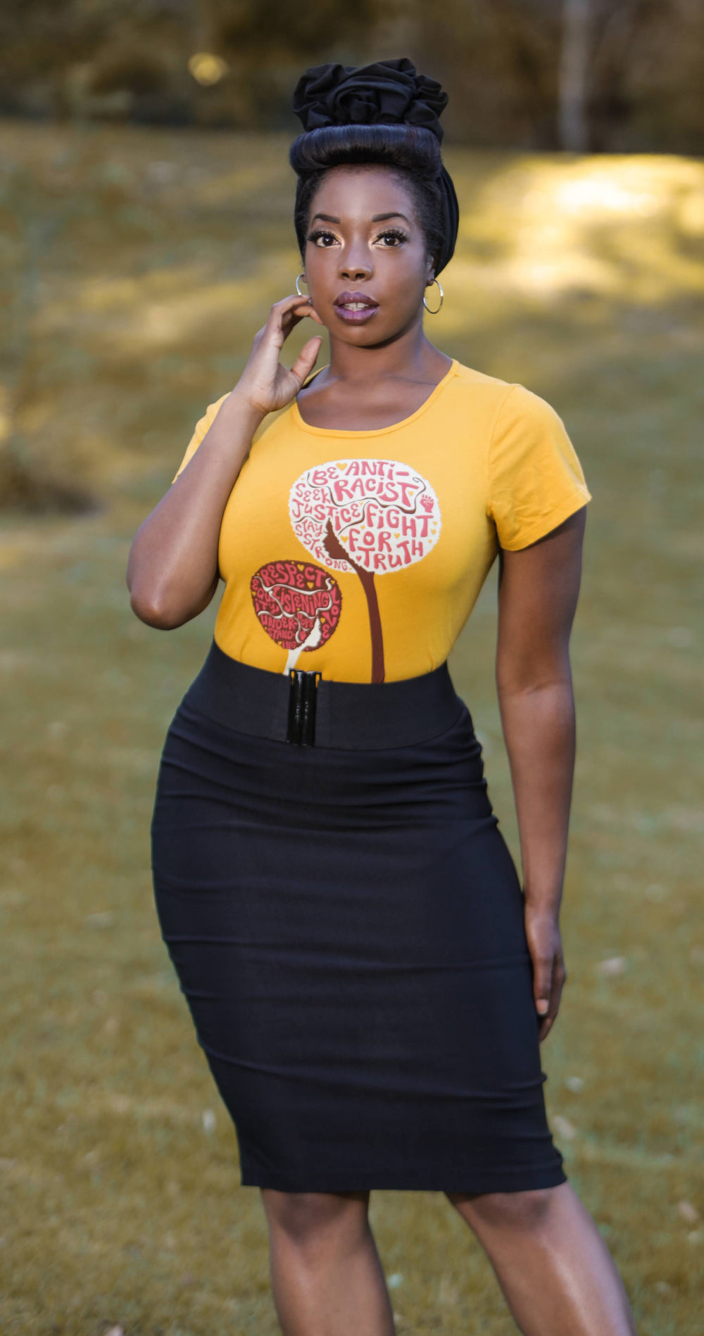 Yellow womens tee featuring afro flowers with anti racist messages on strong Black model