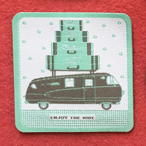 Iron on patch featuring a grey motorhome, suitcases on top, and Enjoy the Ride with mint green polka dots and border