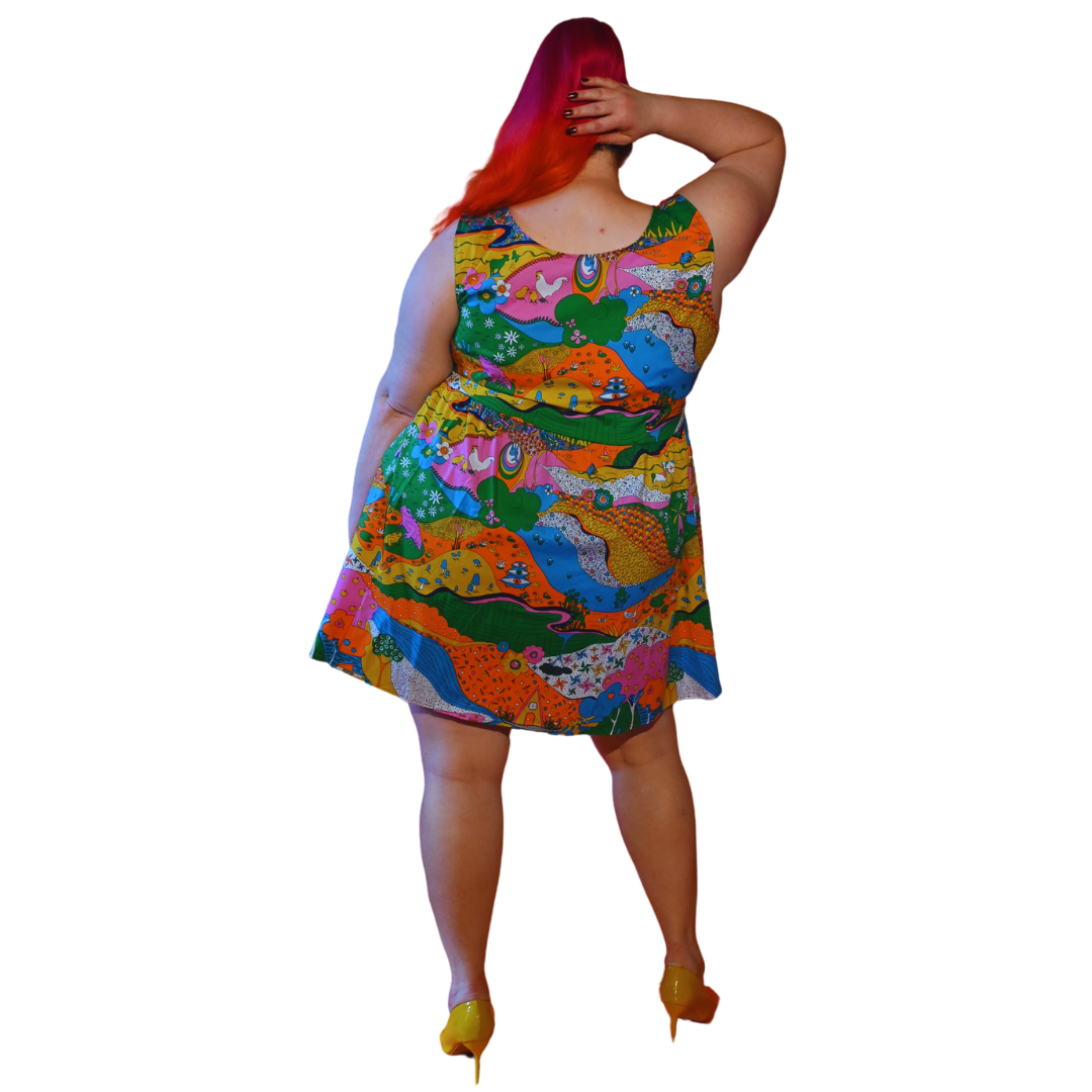Back view of pink-haired girl in rainbow colored landscape print fit & flare dress