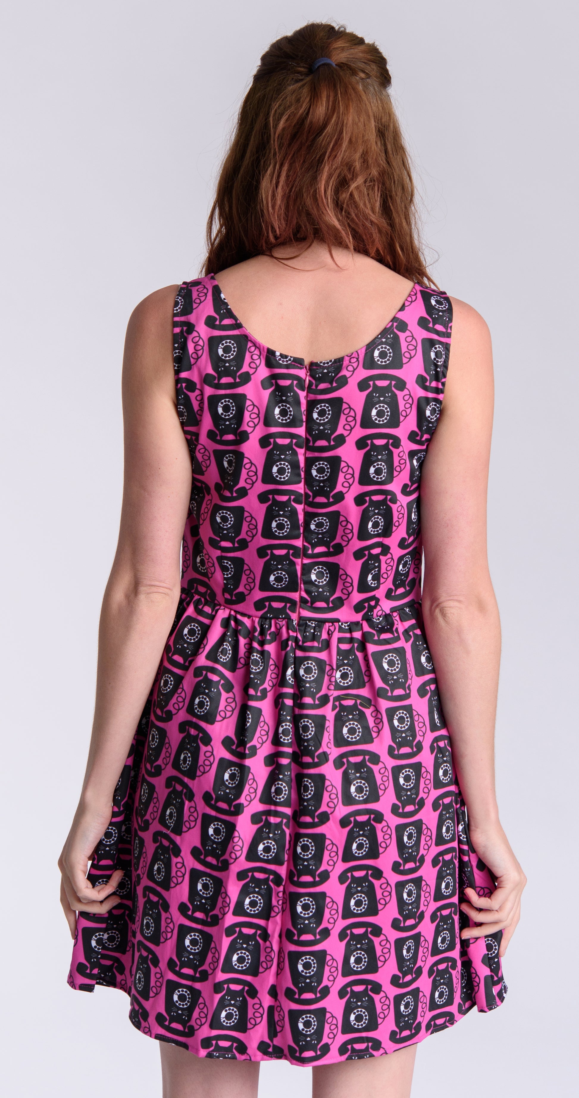 Back view of model wearing bright pink black and white fit and flare dress