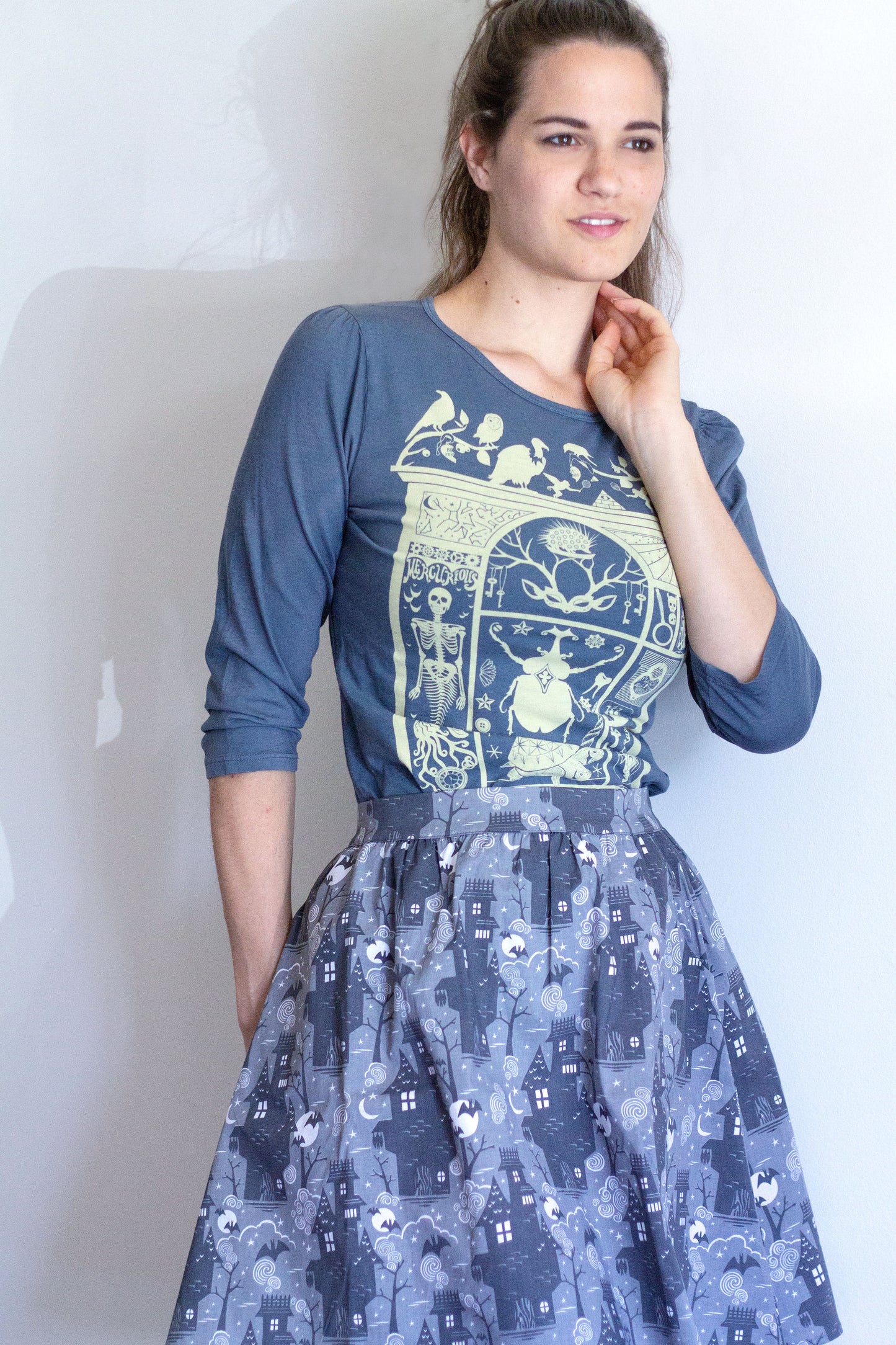Grey 3/4 sleeve tee with ruching at shoulder and cabinet of curiosities print in off white with haunted house skirt