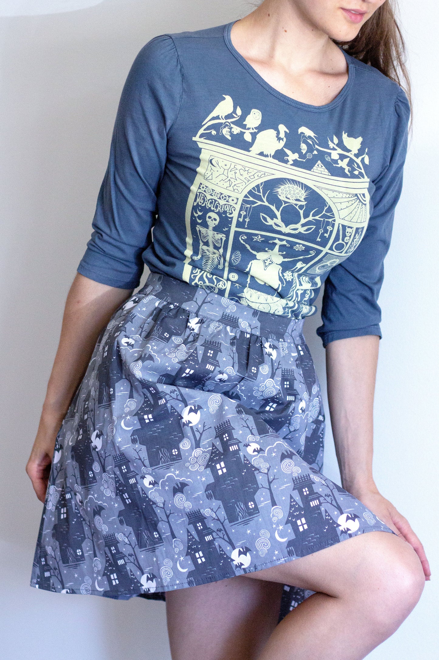 Grey 3/4 sleeve tee with ruching at shoulder and cabinet of curiosities print in off white with grey Halloween skirt