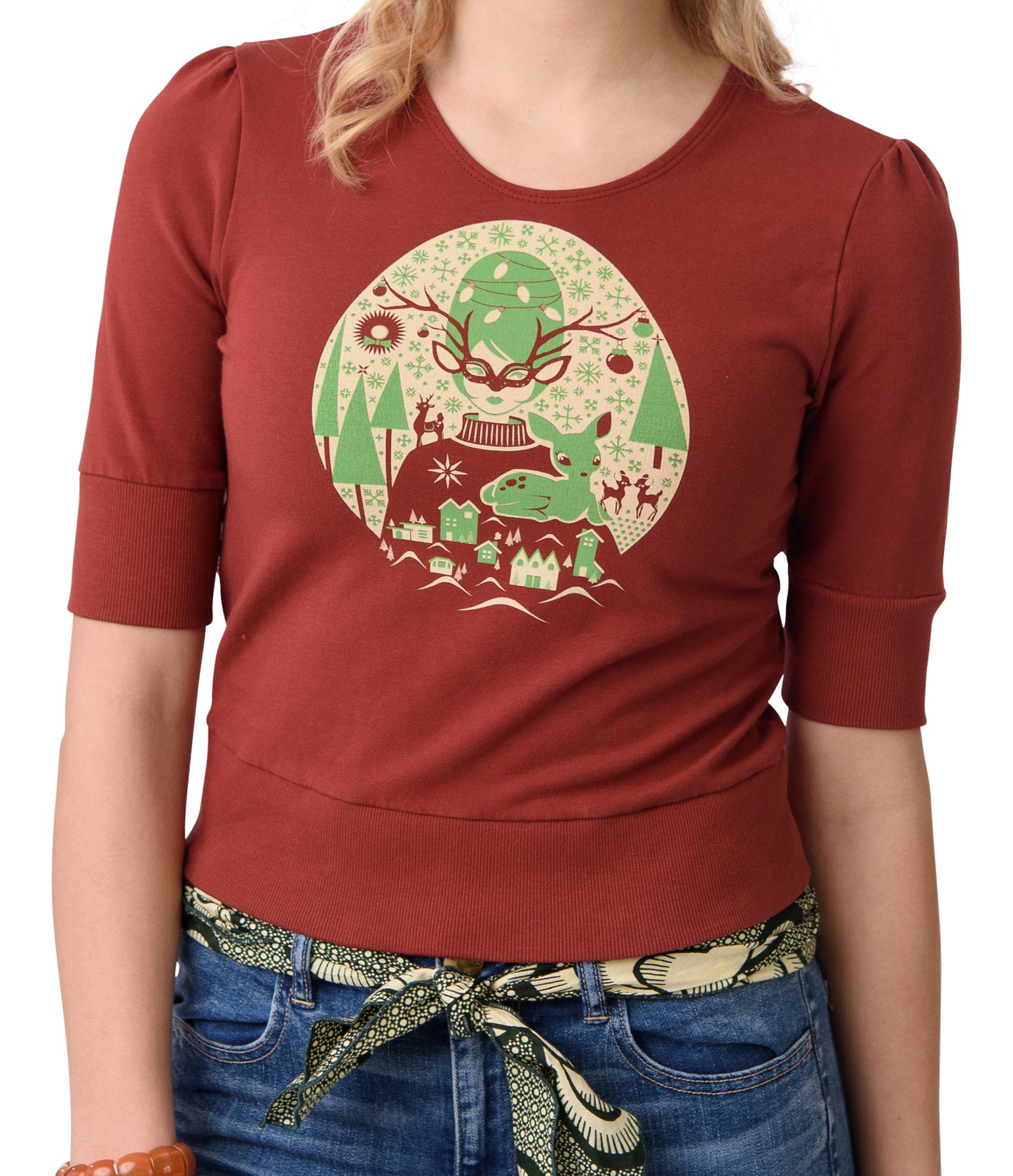 Rust- colored cropped French terry tee with bright green and off white screen print of masked girl with reindeer, trees and snowflakes