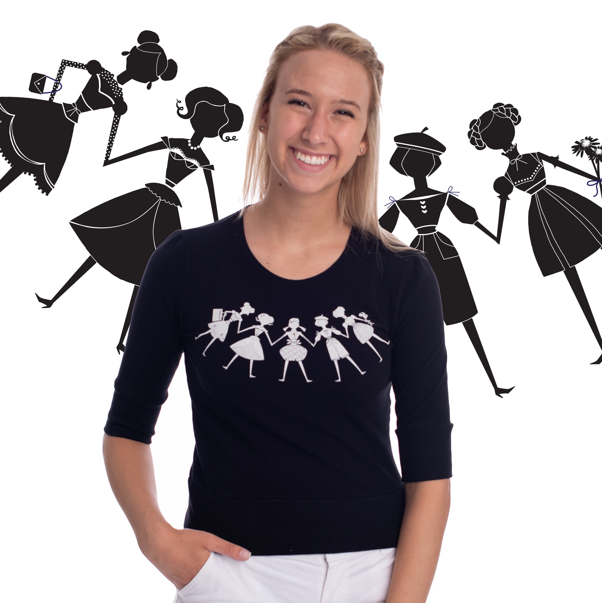 Black French terry cropped shirt featuring white paper dolls print on model with paper doll print backdrop