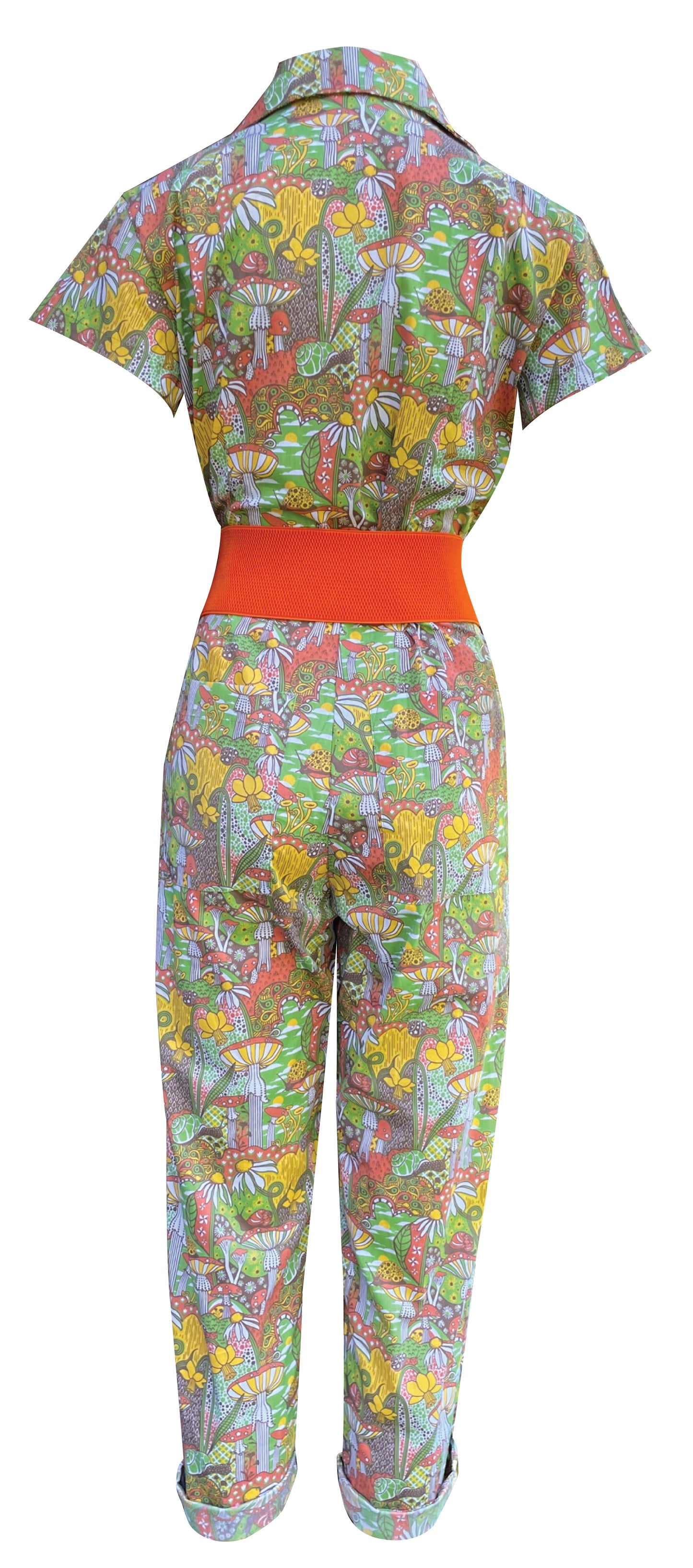 Back view of olive green, orange and yellow mushroom, snail and flower print jumpsuit with big zipper and pockets with orange belt