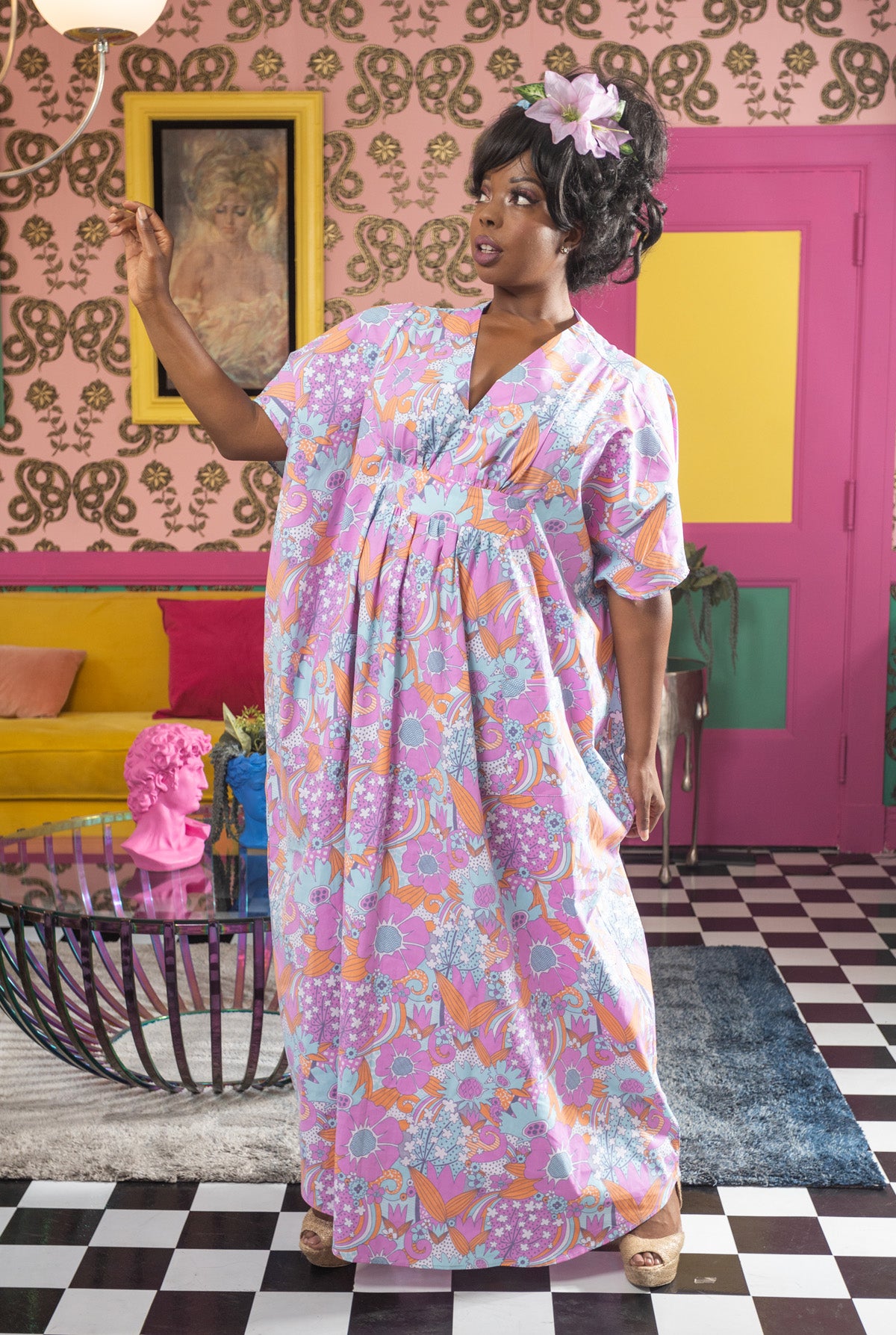 Model with hair flower in long orange pink and blue caftan