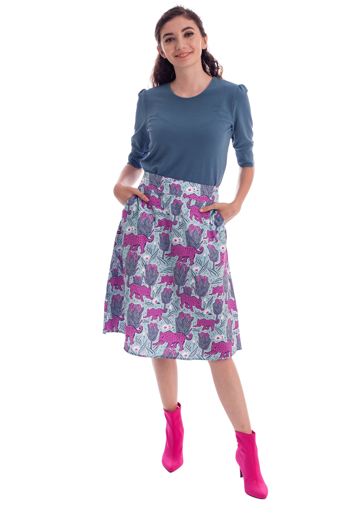 Pink and mint green a-line knee length skirt with flower and jaguar print on model with grey tee and pink ankle boots