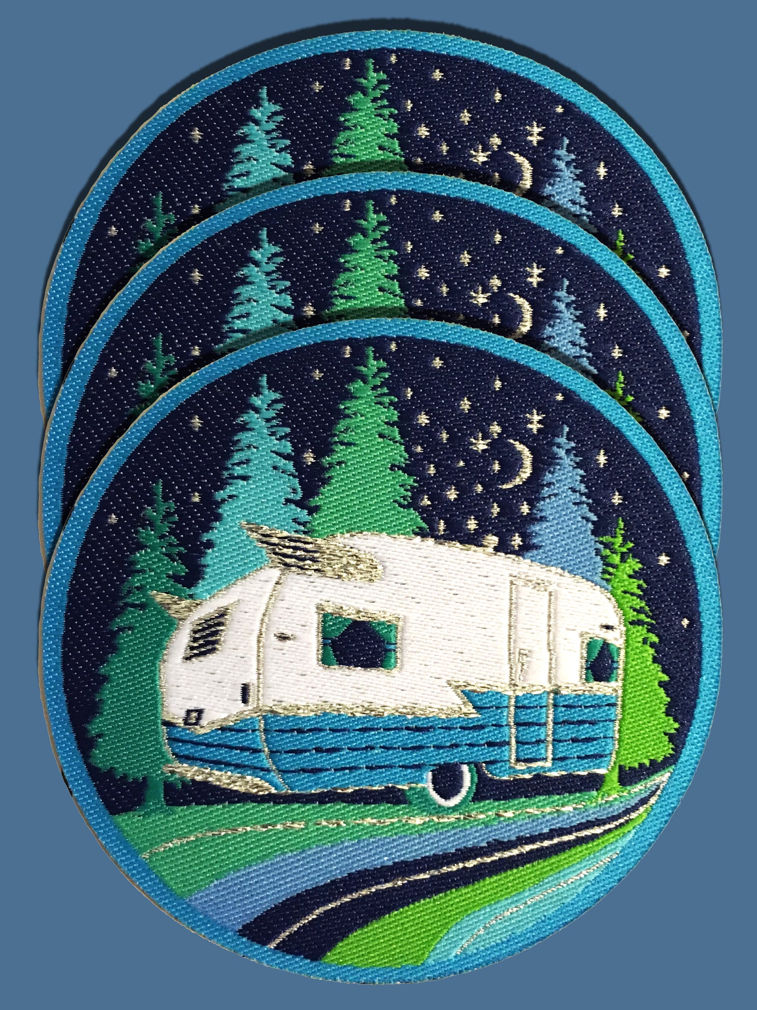 Blue and green iron on patches of vintage Shasta camper and trees 