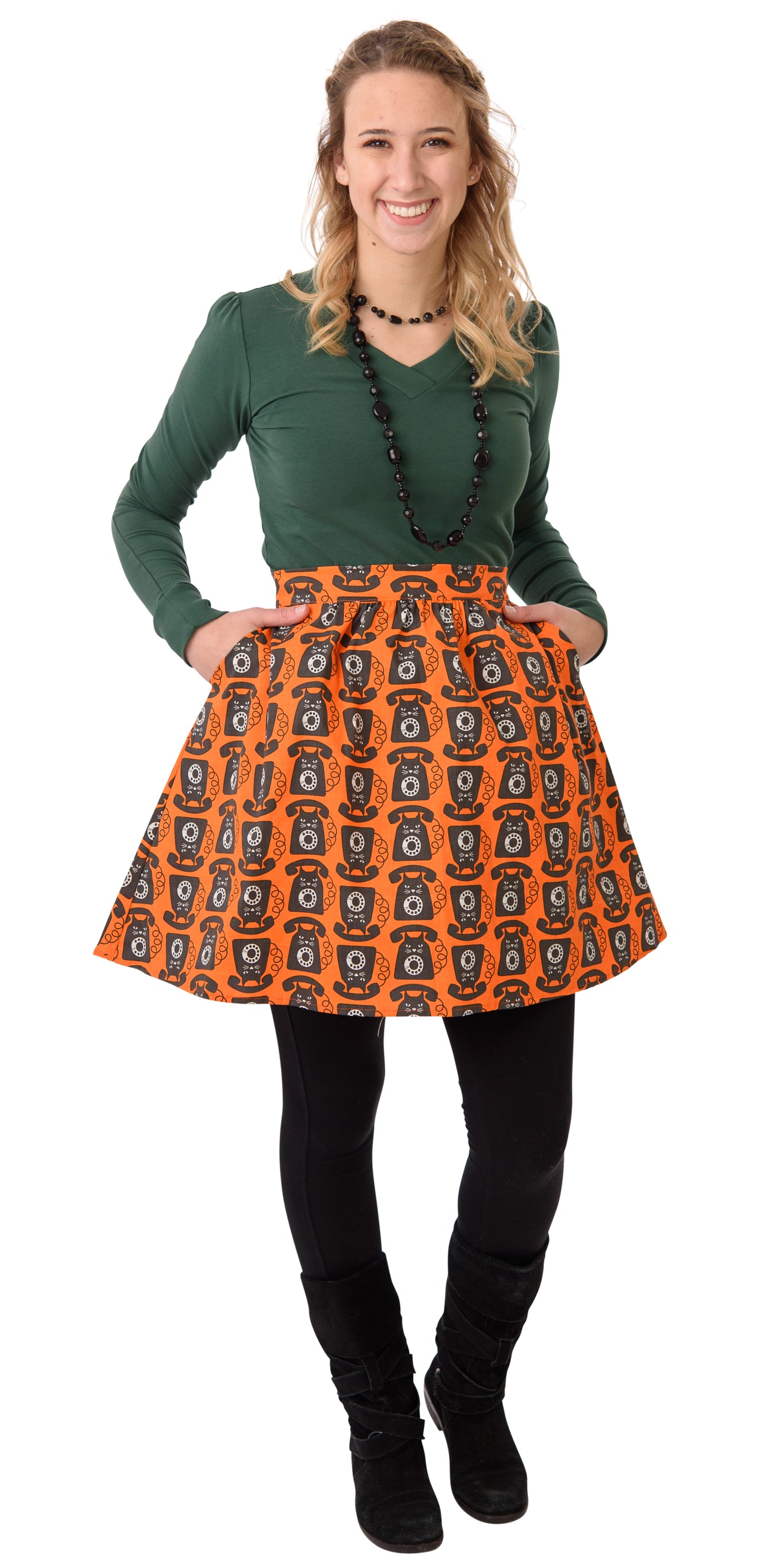 Model wearing bright orange black white gathered cat phone print pocket skirt and pine green v-neck top