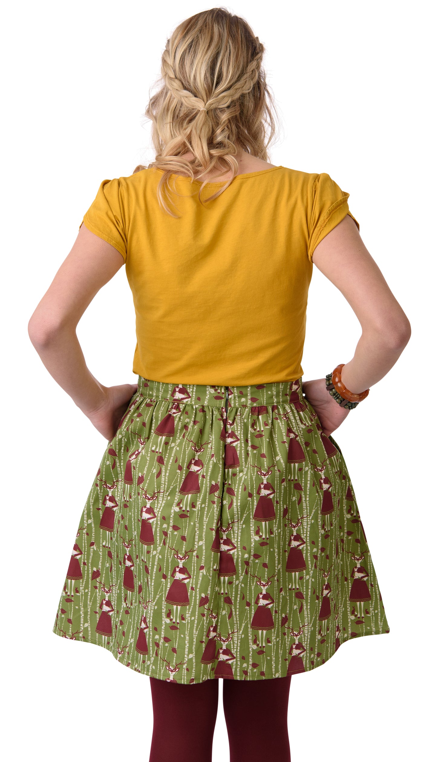 Back view of gathered olive green and brown skirt with deer, birches and masked girl print and pockets