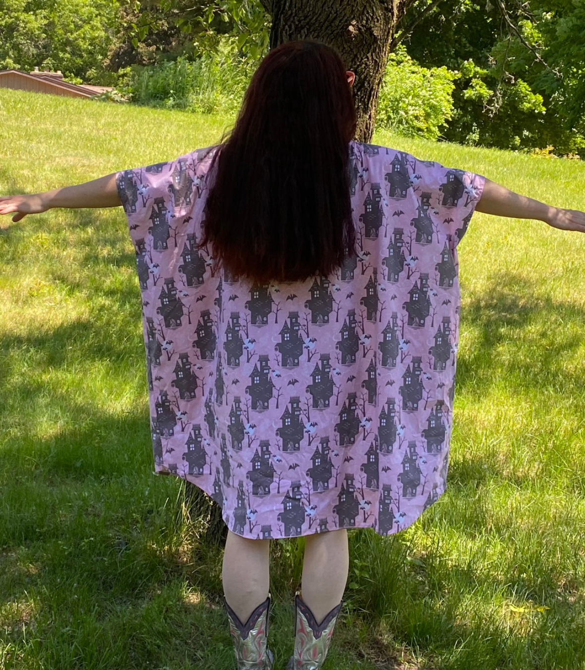 Back view of silly person in pink and grey haunted house print caftan dress