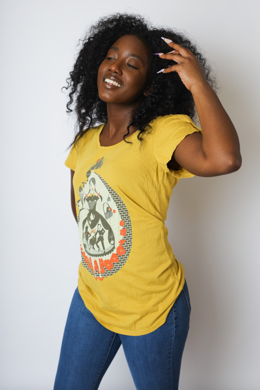 Yellow tulip sleeve Wizard of Oz inspired graphic tee with Dorothy, poppies, dog, scarecrow on curly haired model 