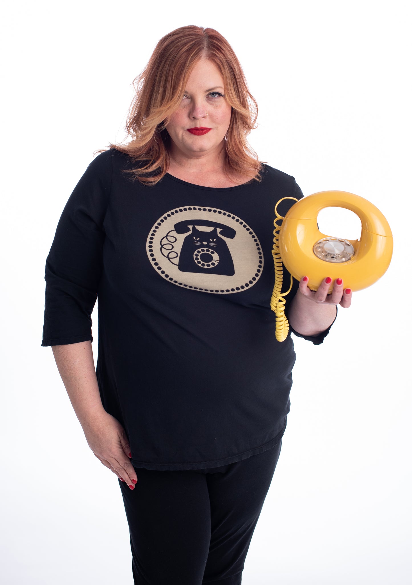 Red haired plus size model holding yellow donut phone while wearing black and white cat phone graphic 3/4 sleeve tee