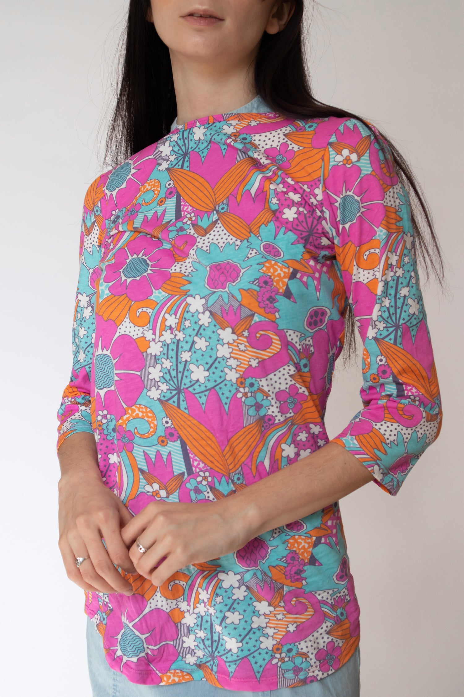 Bright pink, aqua and pink floral 3/4 sleeve cotton tee untucked on model