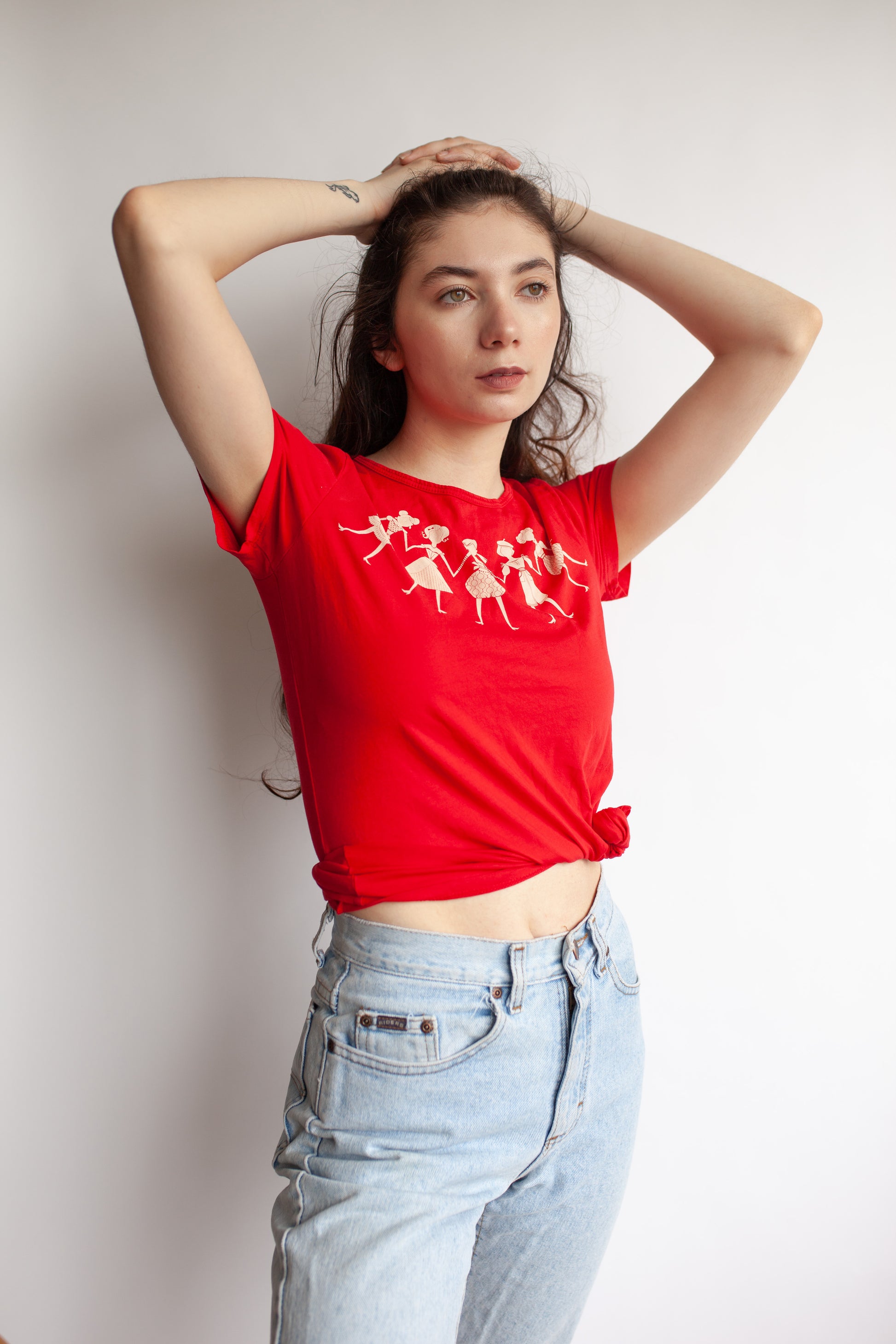 Brunette model wearing red tee with women holding hands