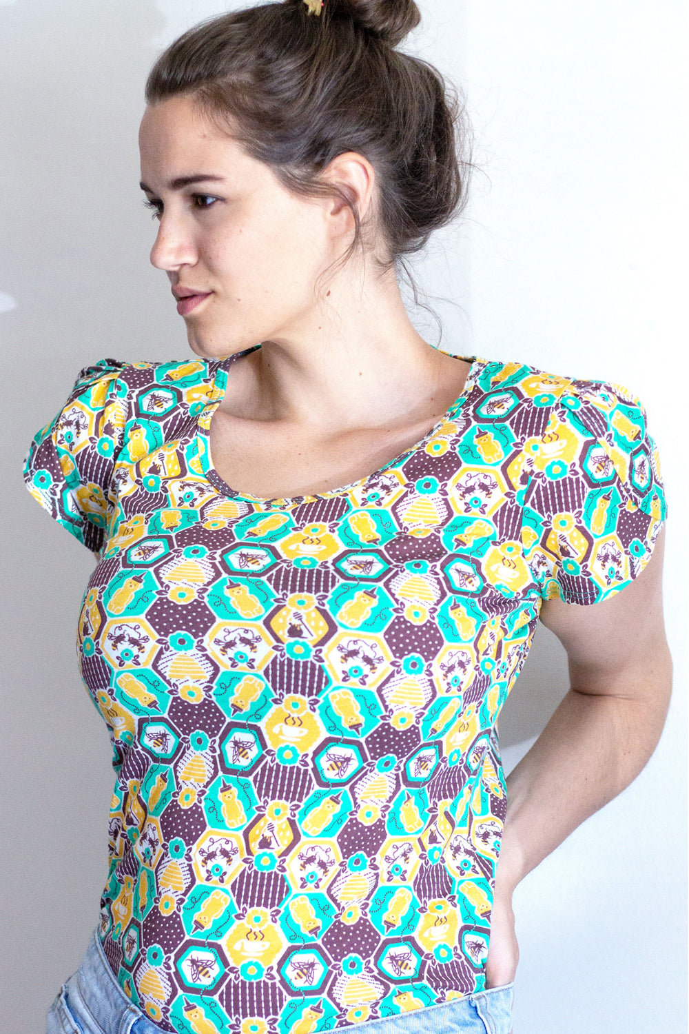 Green, yellow and brown honeycomb, bee and flower print tulip-sleeved tee on model