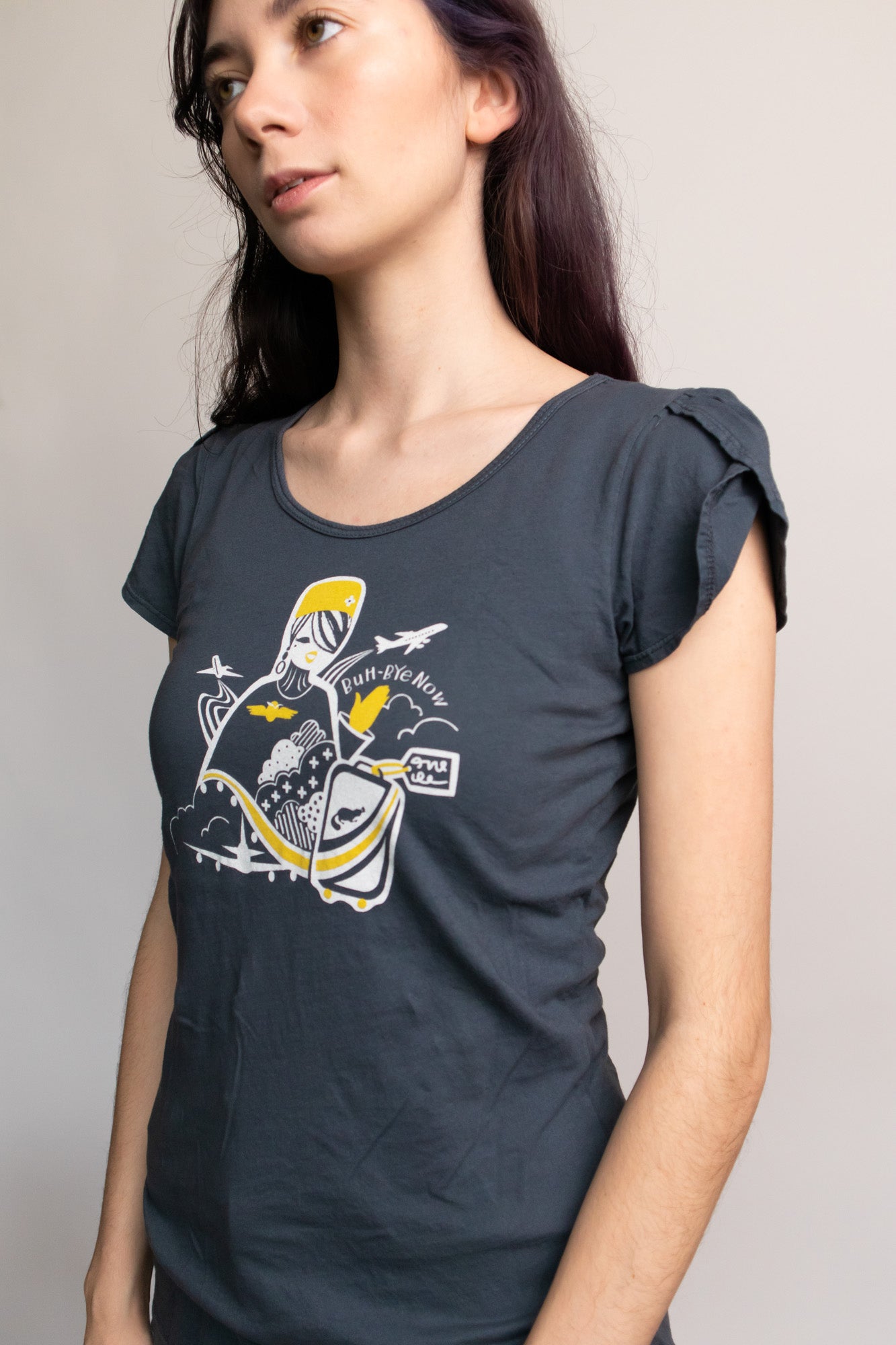 Dark grey shirt with stewardess print and text reading "Buh-bye, now" on model