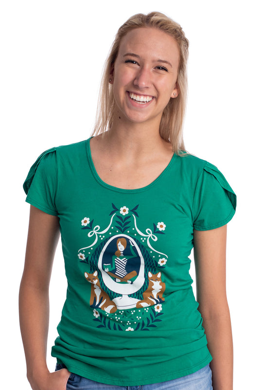 Emerald green tulip-sleeved graphic tee with girl reading a book in an egg chair with 2 foxes