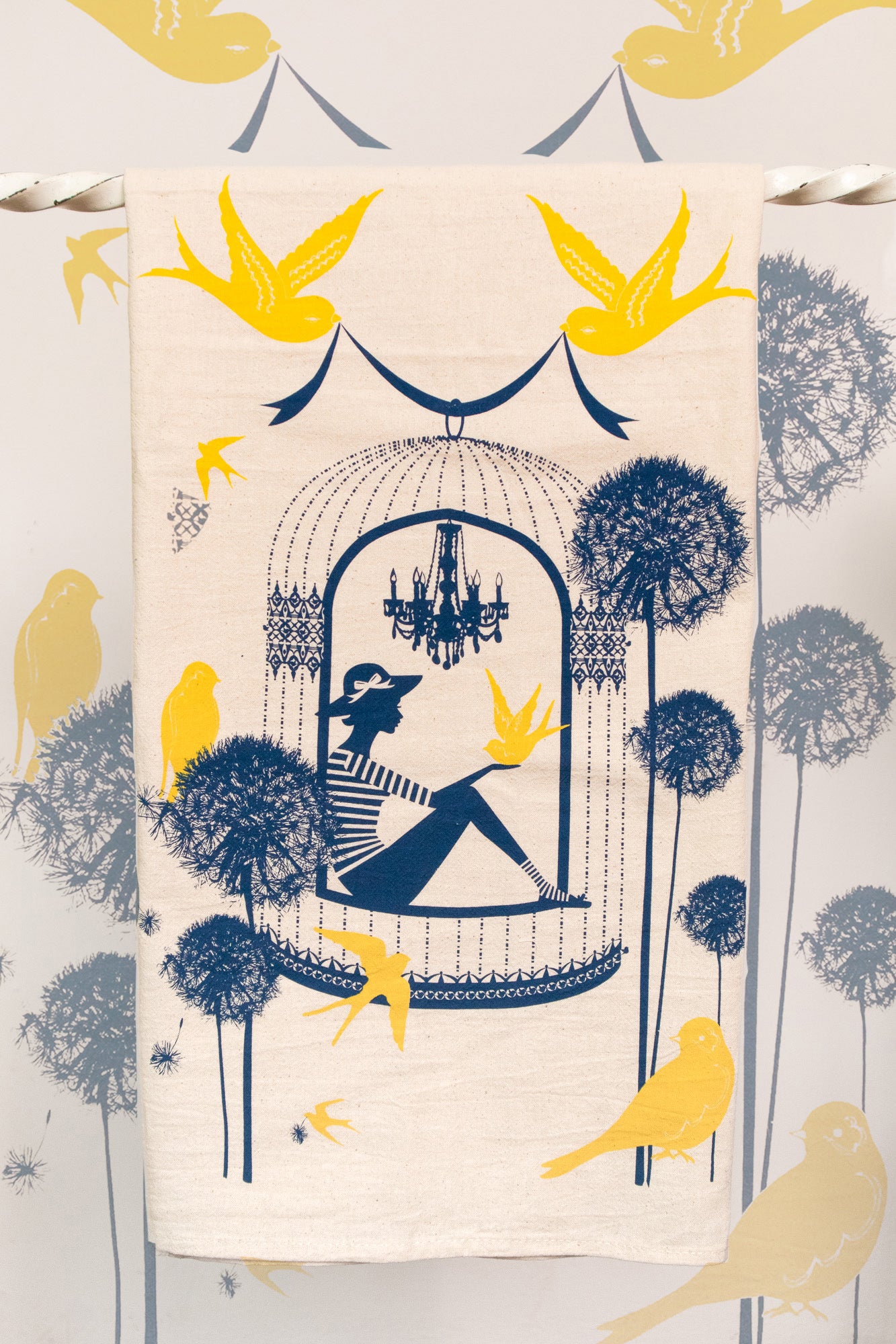 Cotton tea towel with a woman in a birdcage surrounded by birds and flowers
