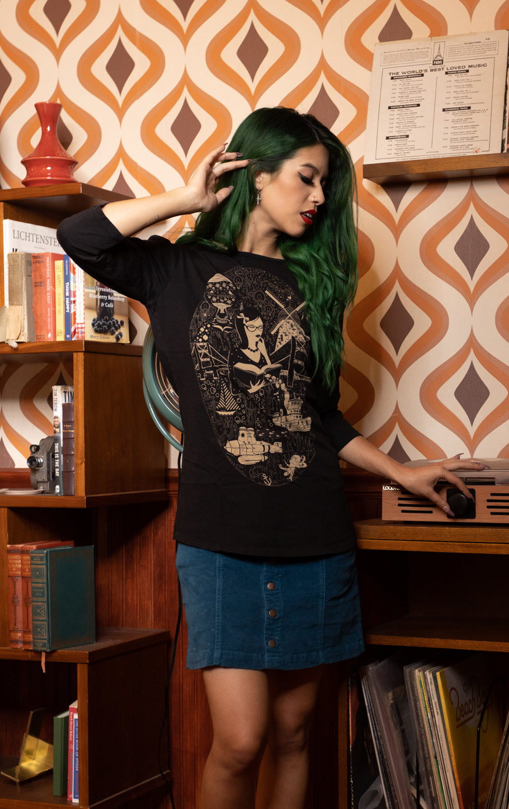 Model in black 3/4 sleeve tee featuring a smart girl reading a book amidst imaginary images