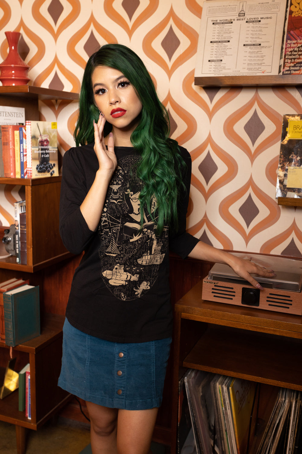 Model in black 3/4 sleeve tee featuring a smart girl reading a book surrounded by intriguing images
