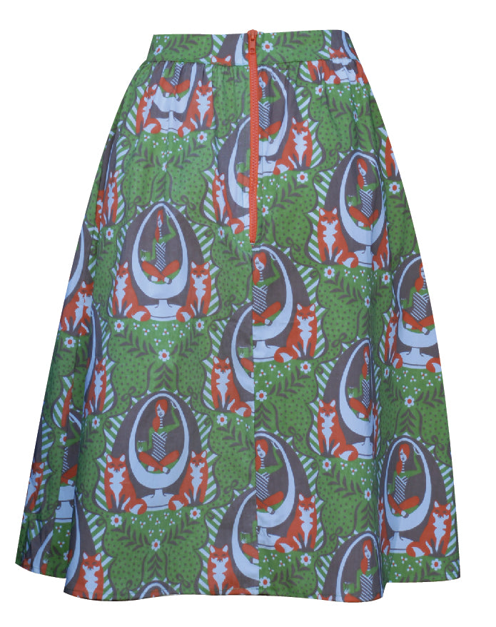 Back view of green and orange gathered midi skirt with print of girl in egg chair, foxes and big orange zip