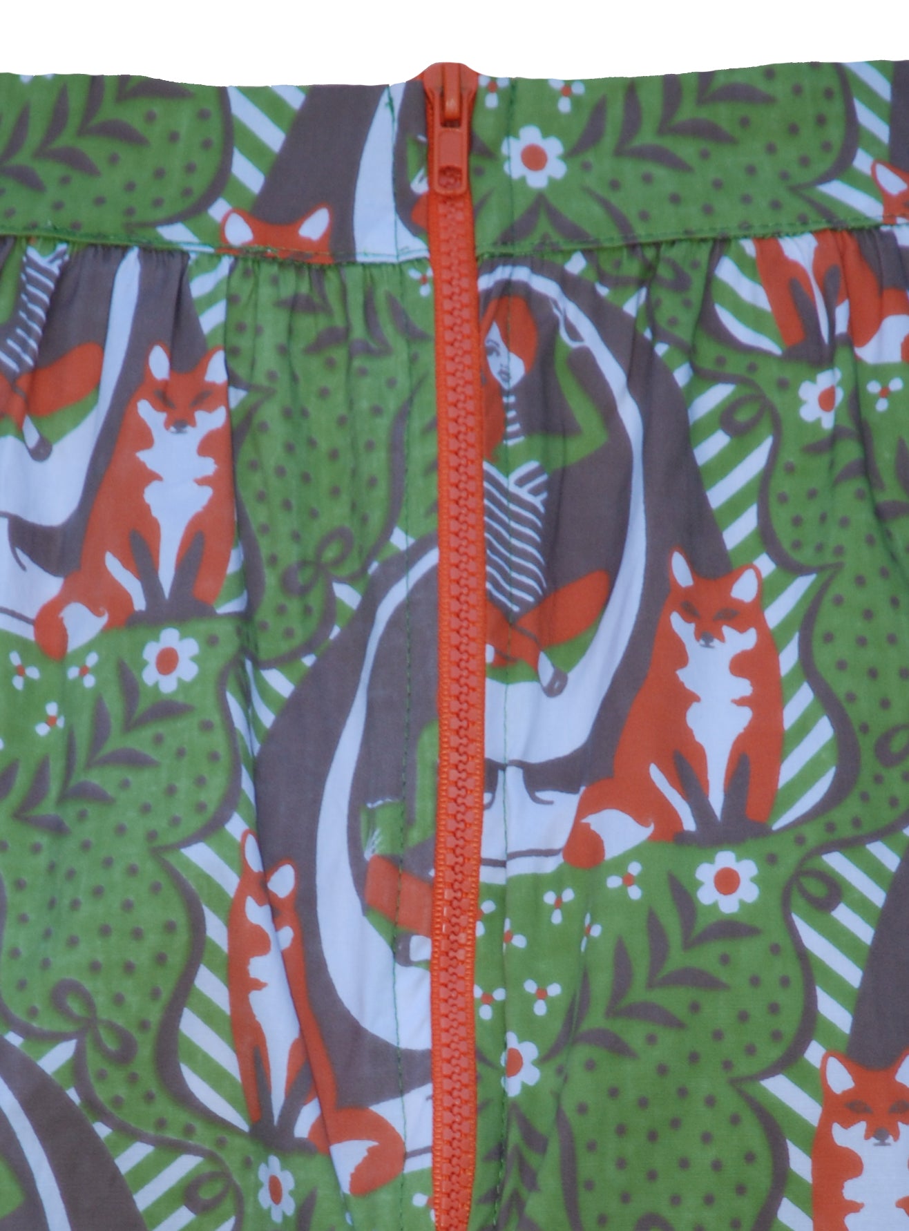 Closeup of skirt back with  print of girl in egg chair, foxes and big orange zip