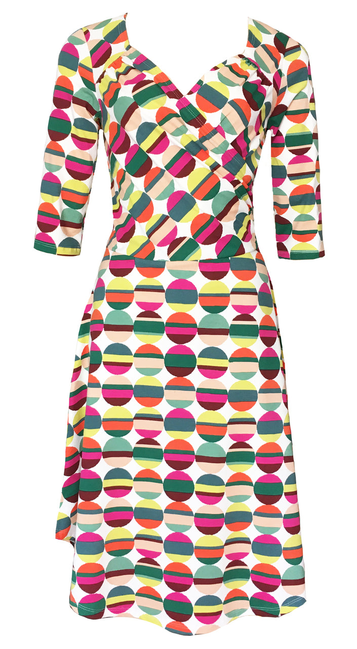 Sleeved surplice knee length wrap dress with bold geometric print of stripes and dots