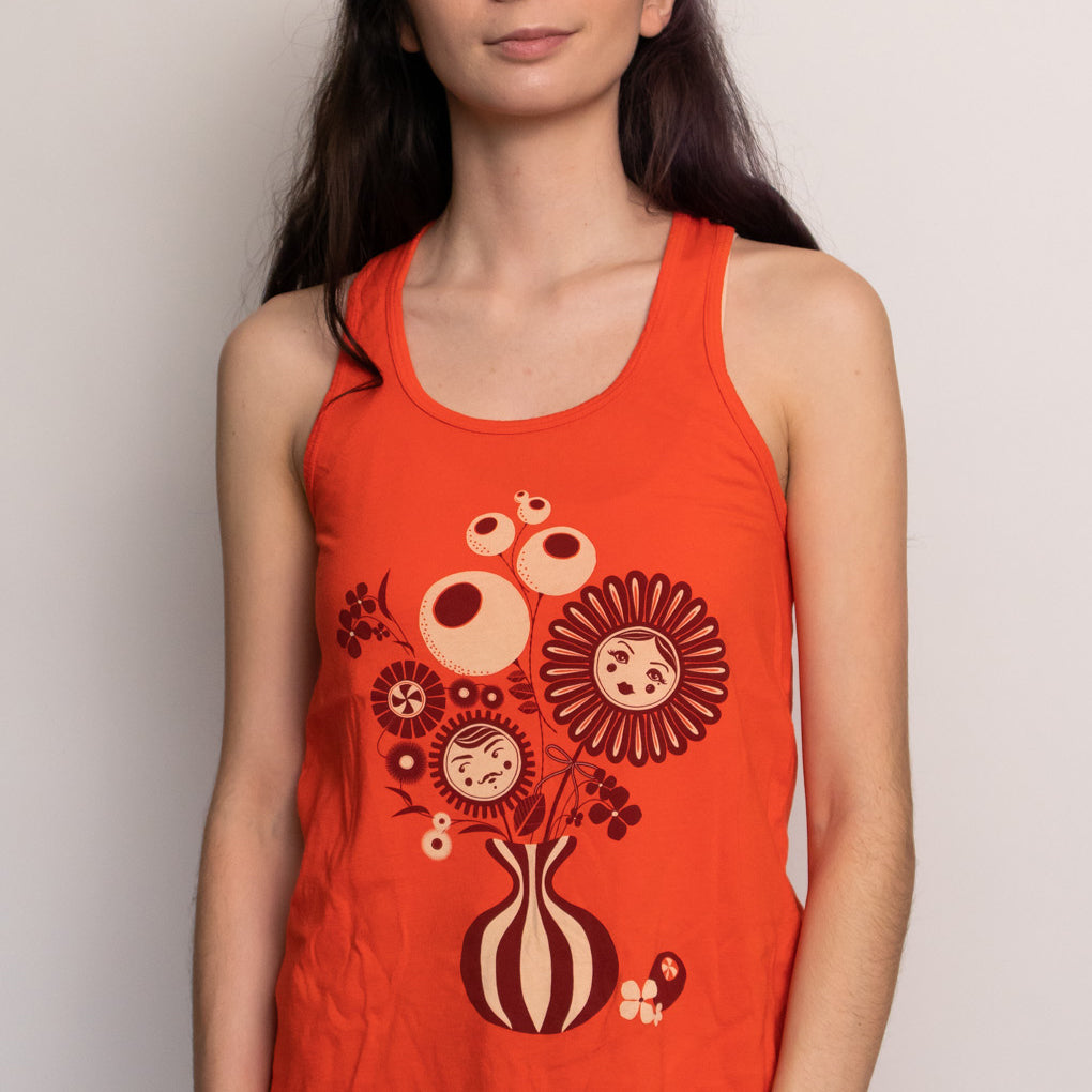 Bright orange tank top with print of flower vase on model 